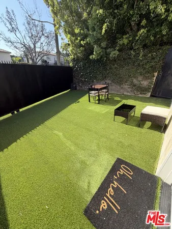 a backyard of a house with table and chairs