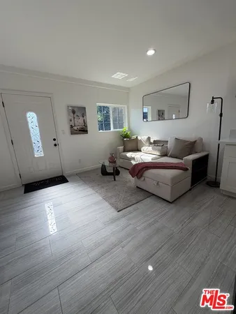 a living room with furniture a flat screen tv and a table