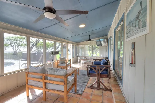 a living room with furniture a flat screen tv and a large window