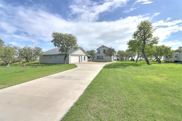 a view of a house with garden and trees