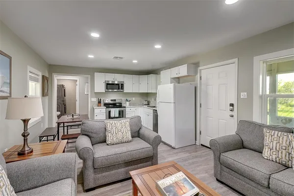 a living room with furniture and a view of kitchen