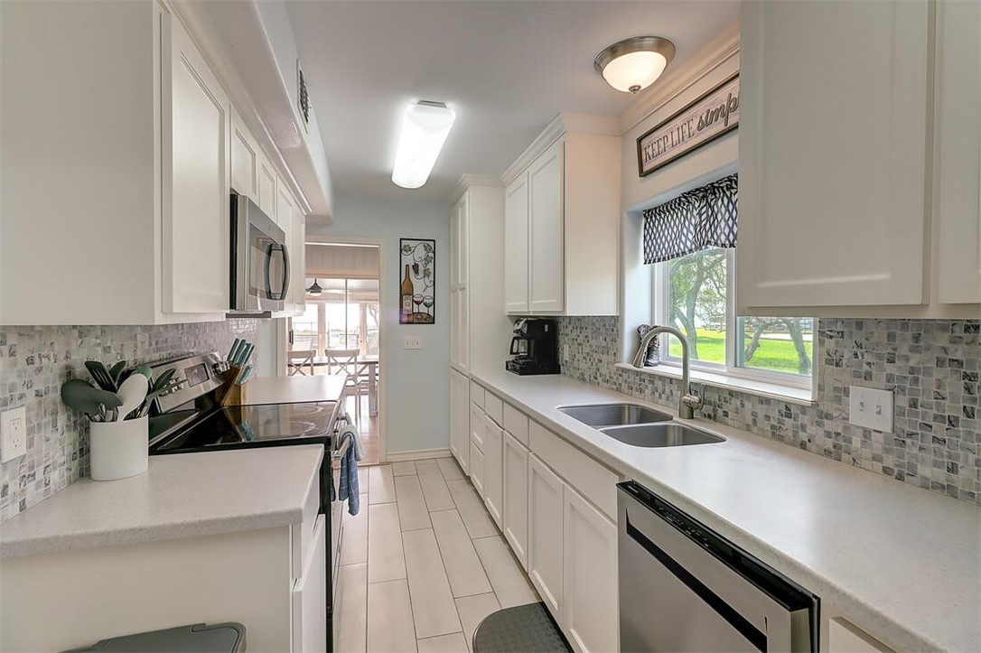 1010 1st Street Bayside, TX 78340 - Photo 6 of 40 a kitchen with a sink and white cabinets