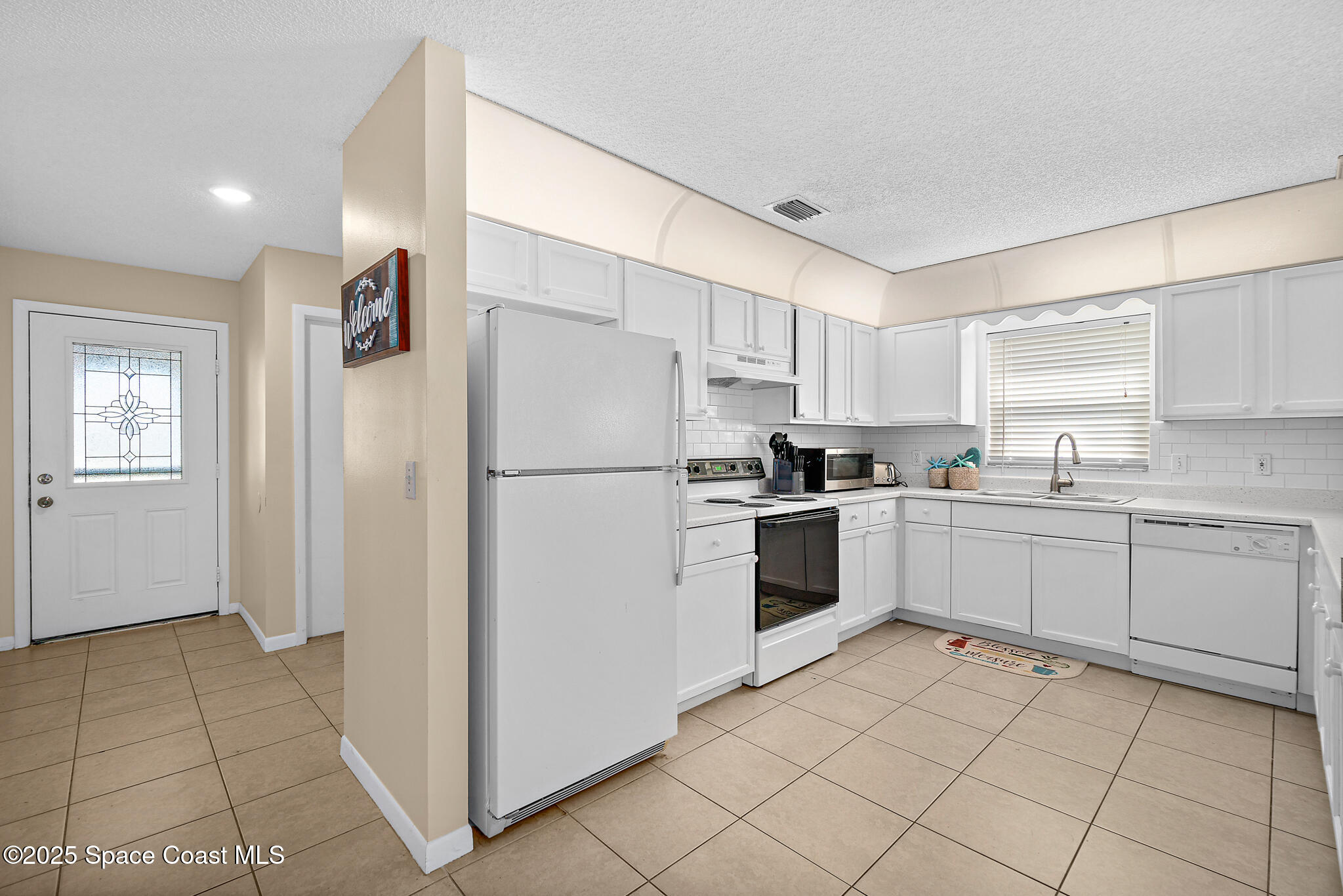 147-159 Ocean View Lane Melbourne, FL 32903 - Photo 11 of 48 a kitchen with a refrigerator sink and cabinets