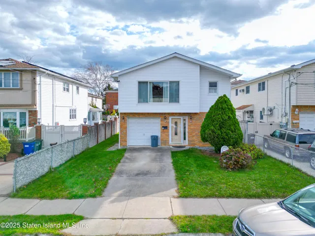 a view of a house with a yard and lawn chairs