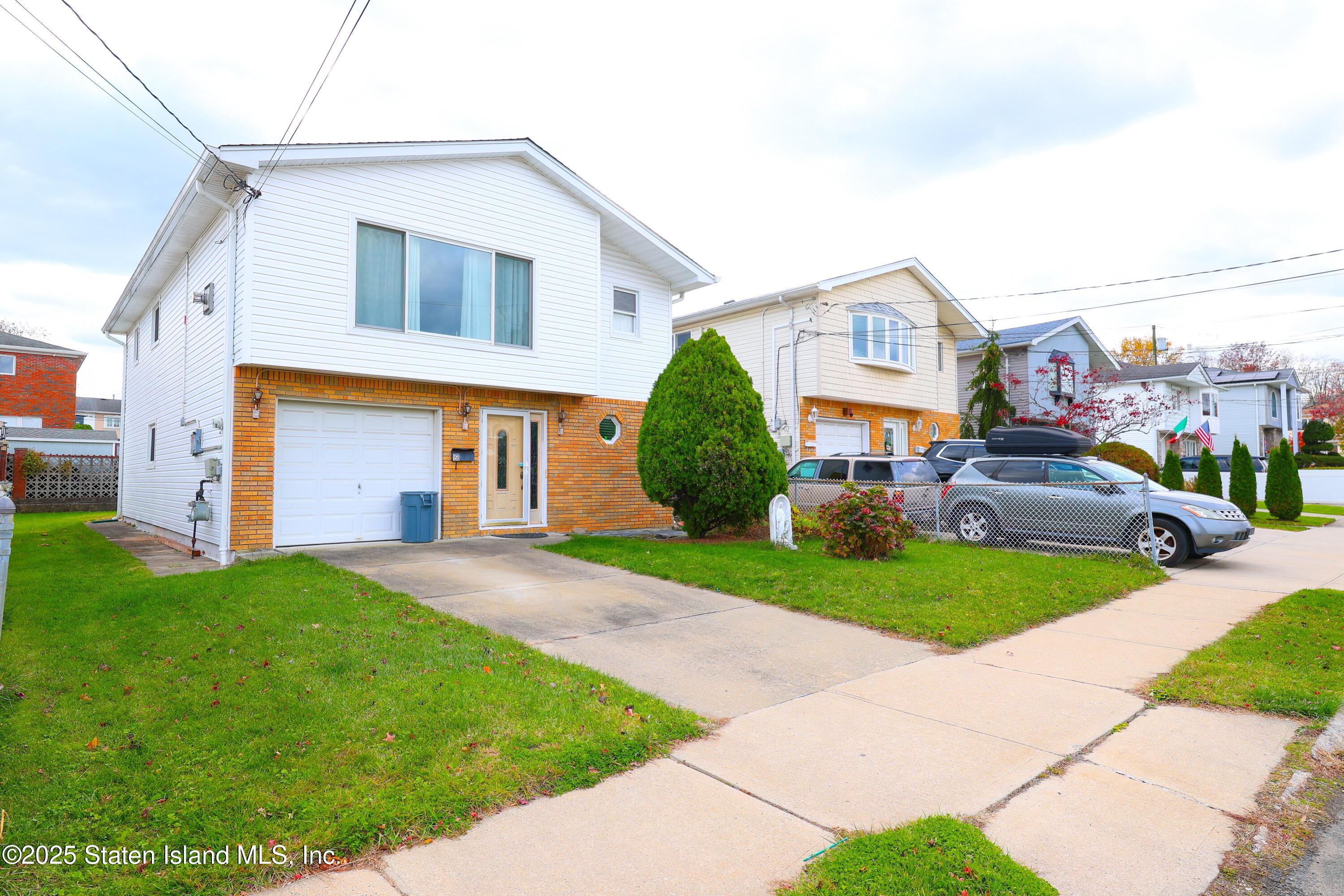 150 Stroud Avenue Staten Island, NY 10312 - Photo 3 of 12 a front view of a house with a yard and garage