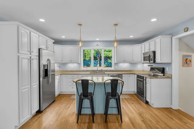 a kitchen with kitchen island wooden cabinets and stainless steel appliances