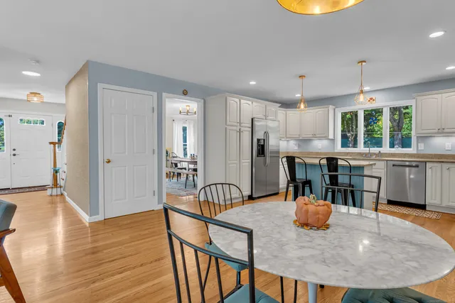 a dining room filled chandelier and wooden floor