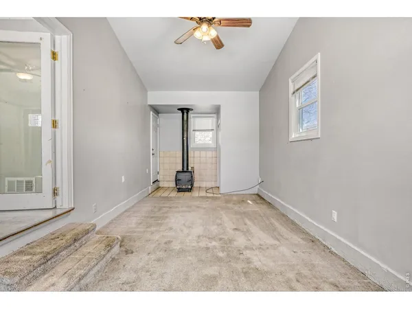 an empty room with windows and cabinet