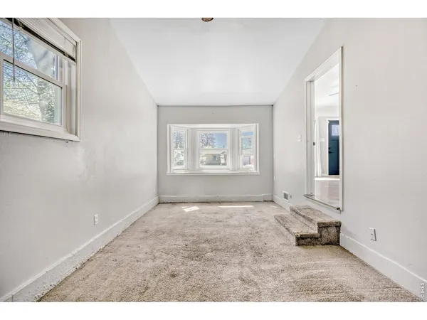 an empty room with windows and closet