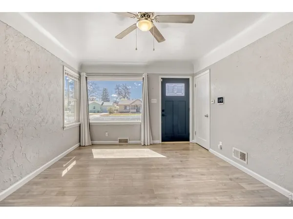 a view of an empty room with window and cabinet