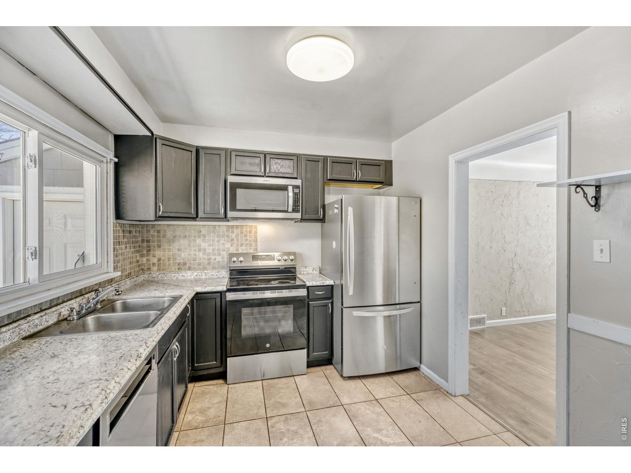 1807 7th Street Greeley, CO 80631 - Photo 4 of 17 a kitchen with granite countertop a refrigerator stove and sink