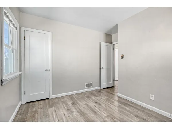 a view of an empty room with wooden floor
