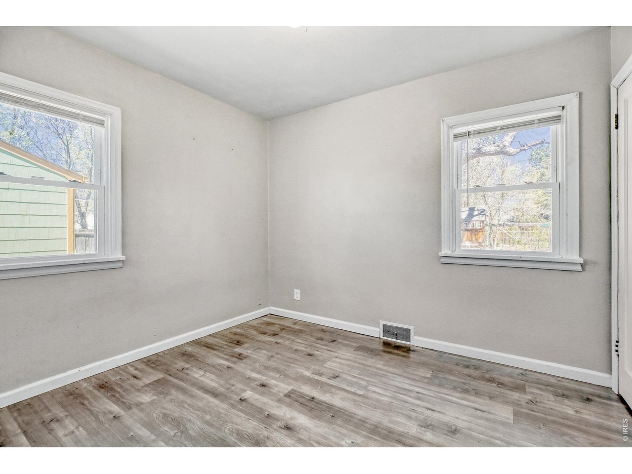 1807 7th Street Greeley, CO 80631 - Photo 7 of 17 a view of an empty room with wooden floor and a window