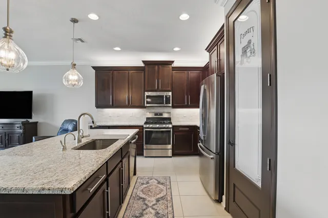 a kitchen with granite countertop a sink cabinets and stainless steel appliances