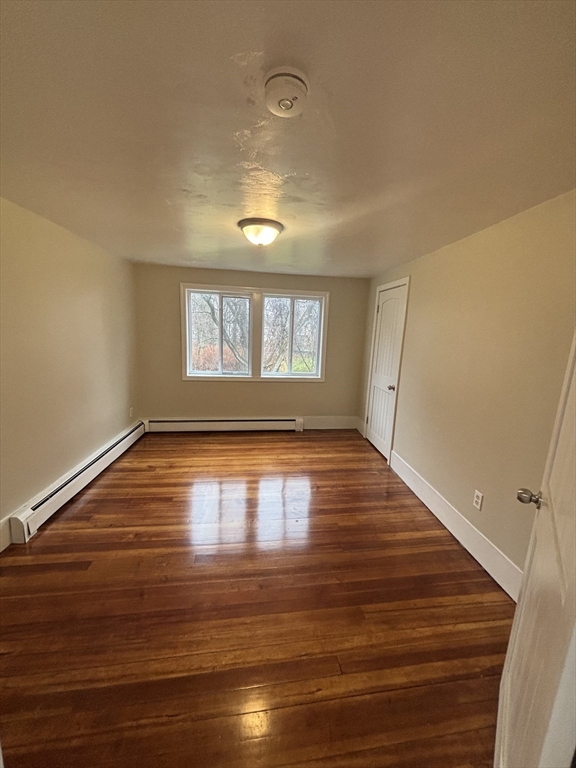 11 Williams Street Dudley, MA 01571 - Photo 11 of 16 a view of empty room with wooden floor and fan