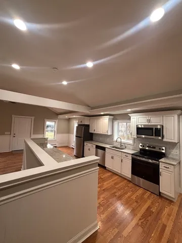 a kitchen with stainless steel appliances granite countertop a sink dishwasher stove top oven and refrigerator