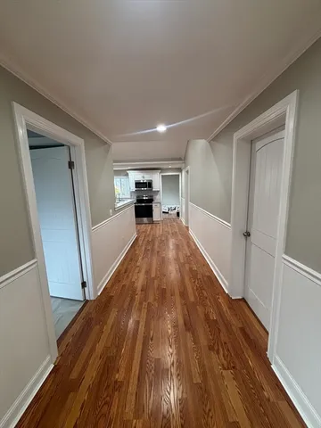 a view of a livingroom with wooden floor and staircase