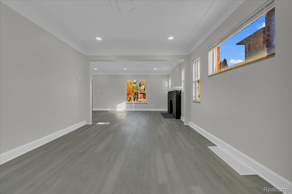 16717 Fielding Street Detroit, MI 48219 - Photo 13 of 46 Unfurnished living room with dark wood-style flooring, a brick fireplace, and recessed lighting