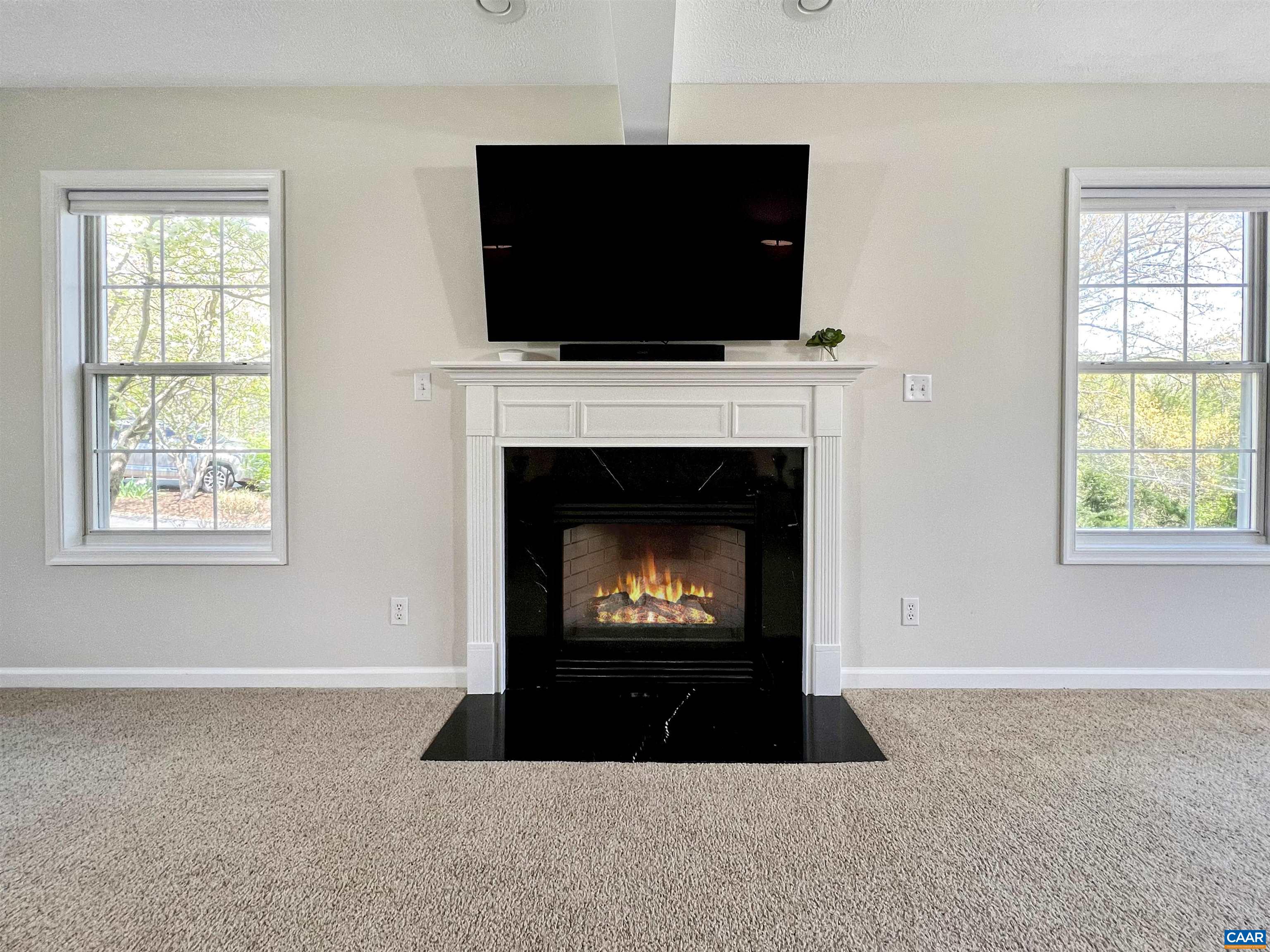 257 Starcrest Road Charlottesville, VA 22902 - Photo 24 of 65 a living room with a fireplace a flat screen tv and a window