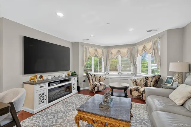 a living room with furniture a flat screen tv and a large window
