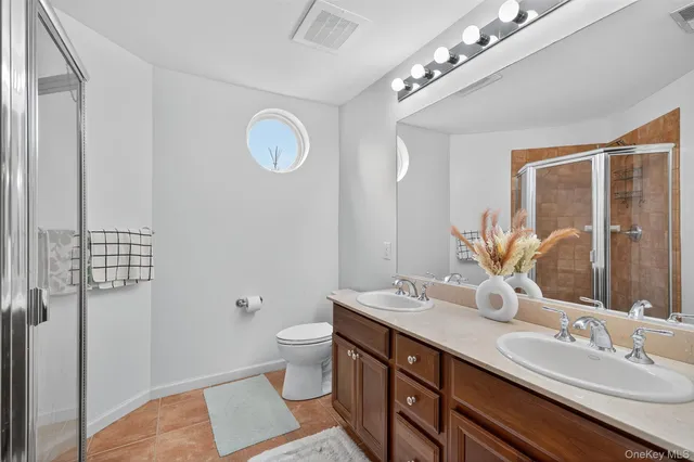 a bathroom with a double vanity sink a mirror and a shower