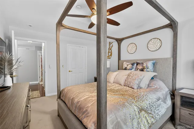 a bedroom with a bed and a large mirror on the dresser