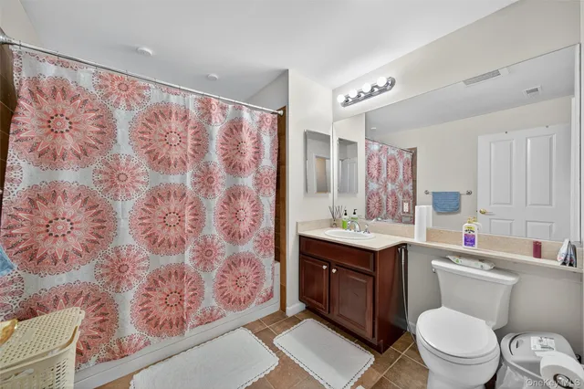 a bathroom with a toilet sink vanity granite and mirror