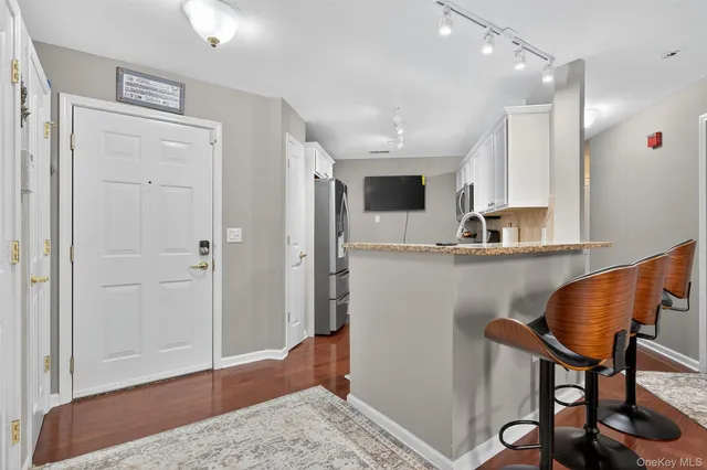 a living room with stainless steel appliances kitchen island granite countertop furniture and wooden floor