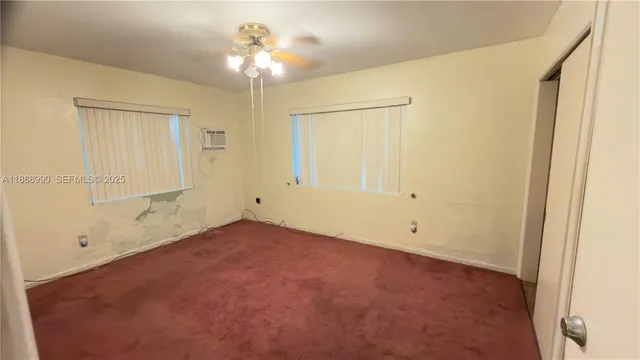 an empty room with a ceiling fan and a window