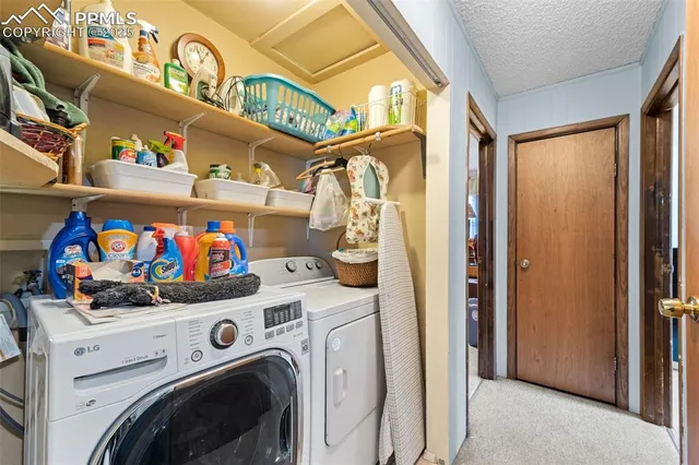 a utility room with fridge dryer and washer