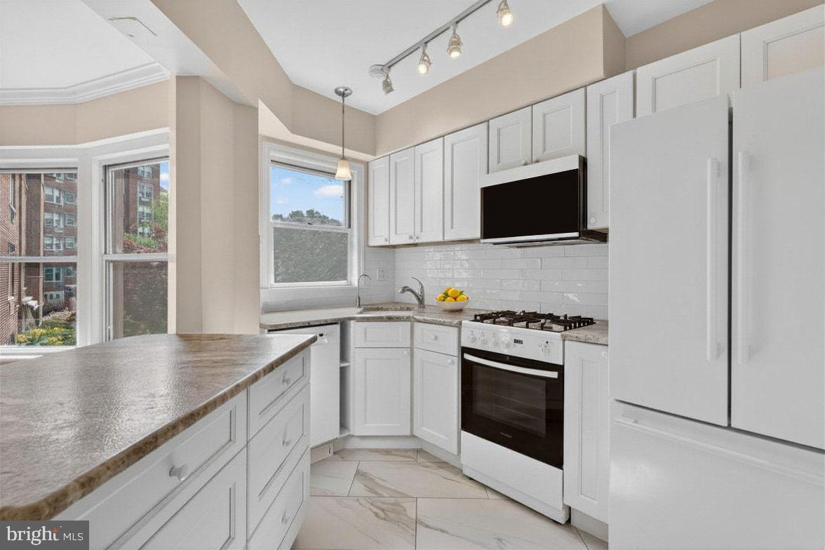 2500 Q Street Northwest, Unit 227 Washington, DC 20007 - Photo 5 of 13 a kitchen with granite countertop white cabinets and stainless steel appliances