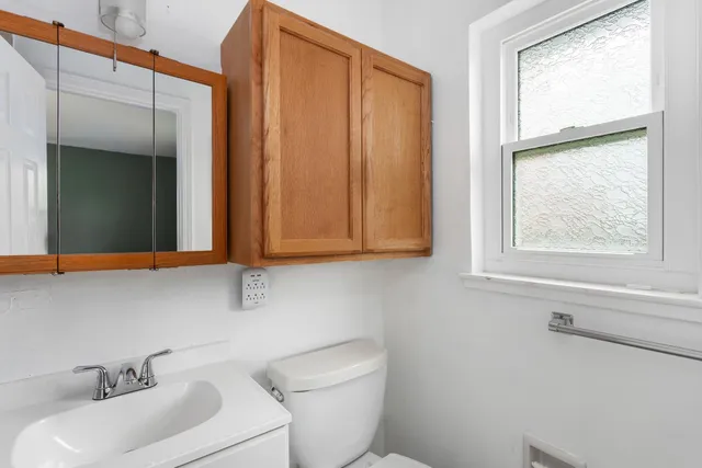 a bathroom with a sink a toilet and mirror