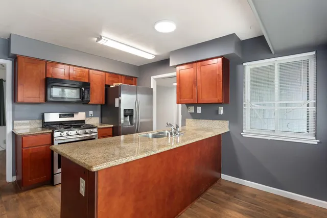 a kitchen with stainless steel appliances granite countertop a sink stove and refrigerator