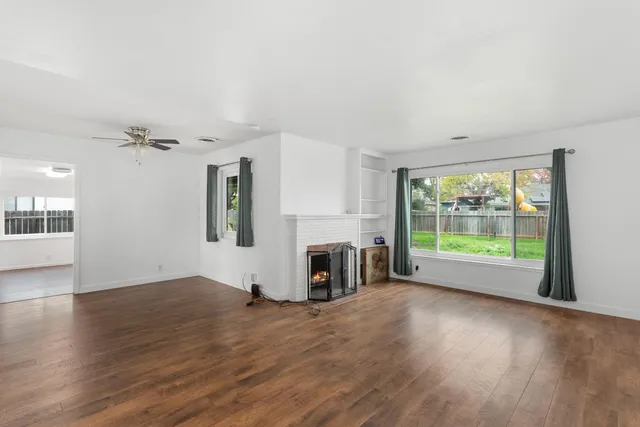 a view of a room with wooden floor and a fireplace