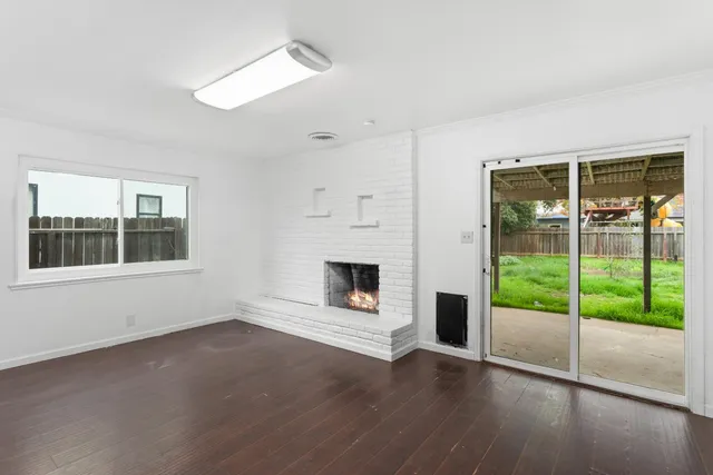 a view of a livingroom with wooden floor and a fireplace