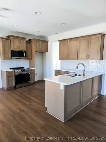 a kitchen with stainless steel appliances granite countertop a sink stove and a refrigerator
