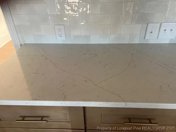 an empty room with wooden floor fireplace and windows