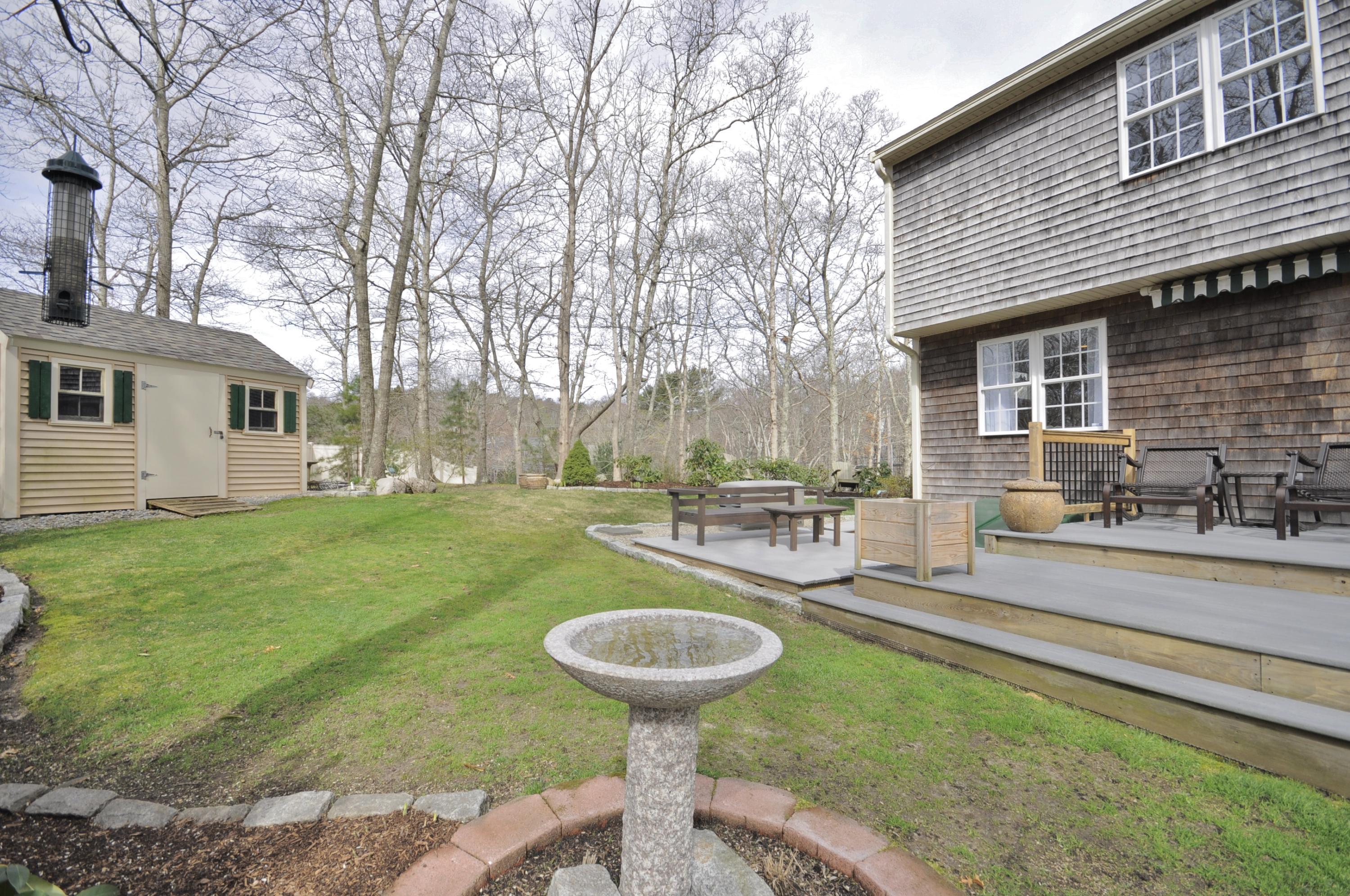 2 Crowell Road Sagamore Beach, MA 02562 - Photo 25 of 27 a view of a backyard with table and chairs potted plants and large tree