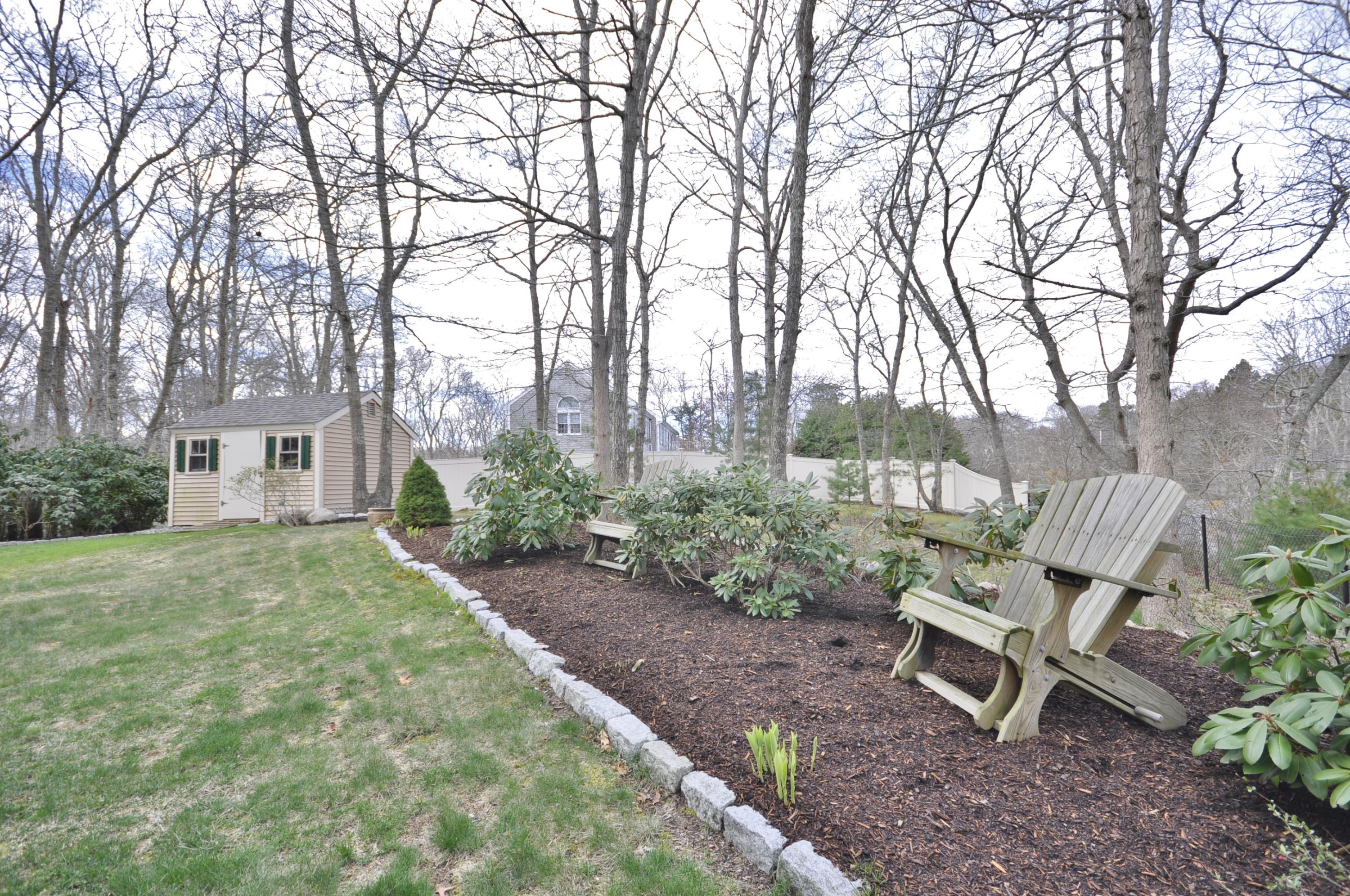 2 Crowell Road Sagamore Beach, MA 02562 - Photo 26 of 27 a view of a backyard with table and chairs and a fire pit