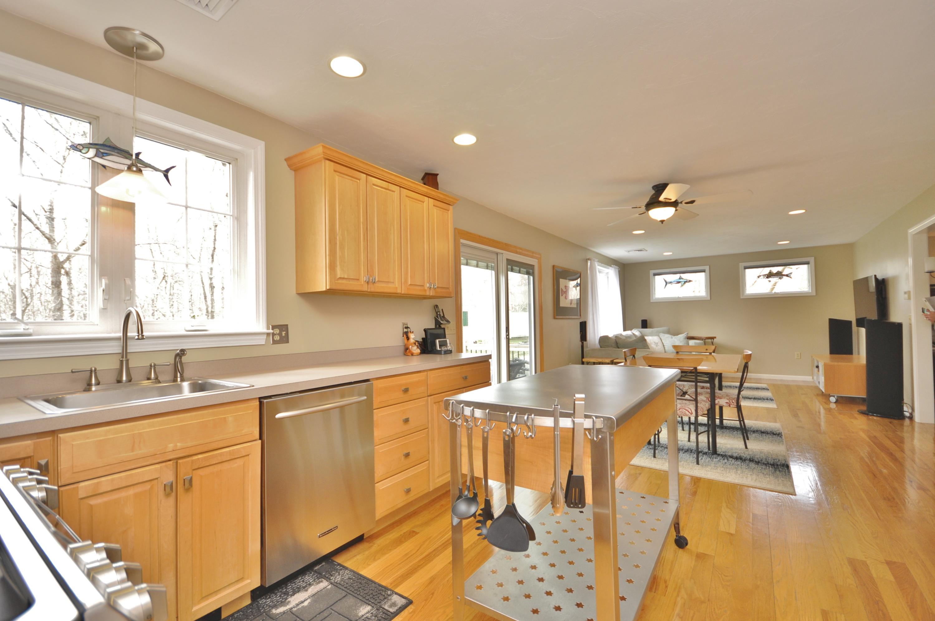 2 Crowell Road Sagamore Beach, MA 02562 - Photo 5 of 27 a dining hall with stainless steel appliances granite countertop a sink a stove a dining table and chairs with wooden floor