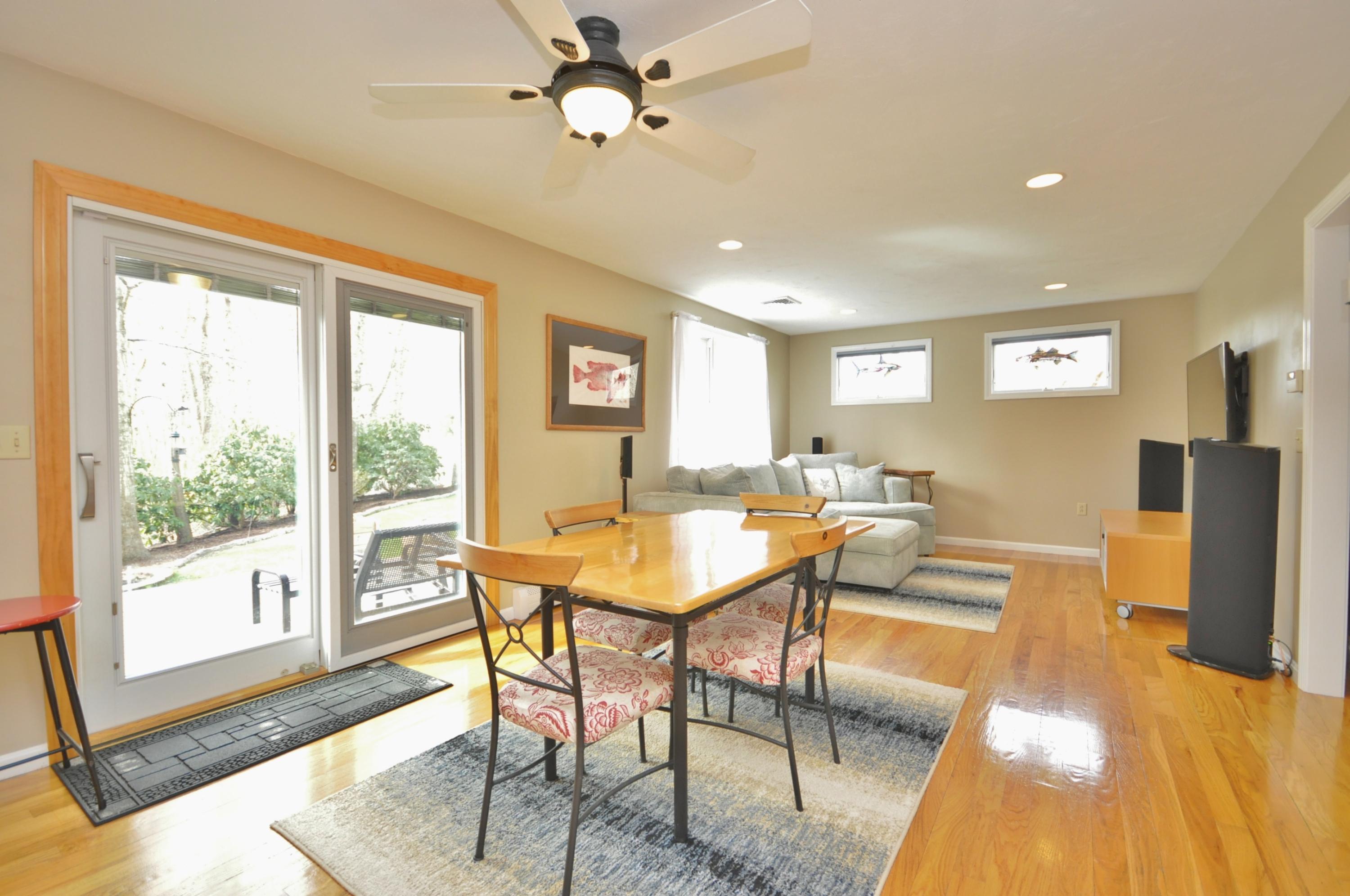 2 Crowell Road Sagamore Beach, MA 02562 - Photo 9 of 27 a dining room with furniture a flat screen tv and a floor to ceiling window