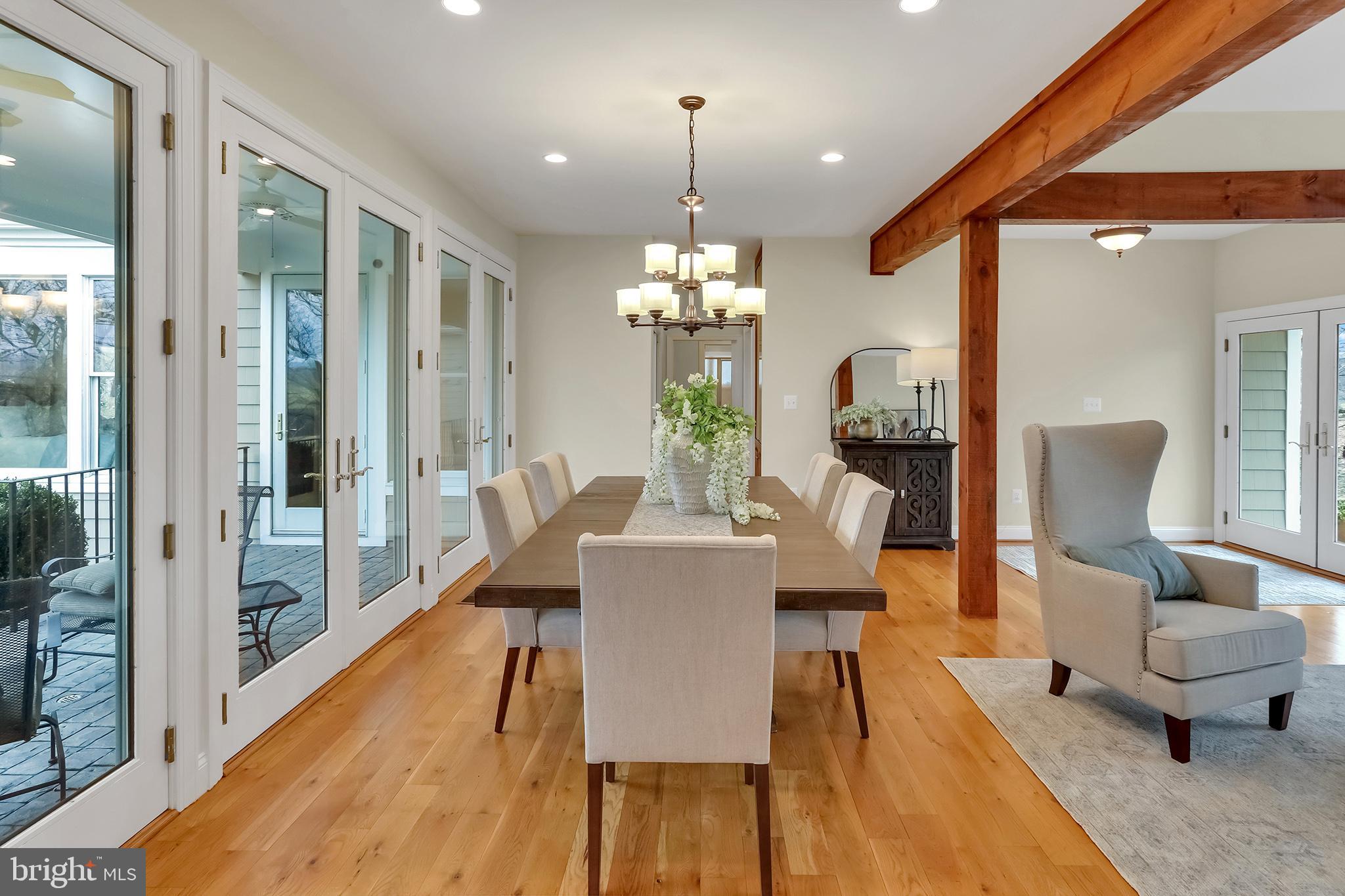 37218 Bolyn Road Purcellville, VA 20132 - Photo 6 of 62 a dining room with wooden floor a chandelier a glass table and chairs
