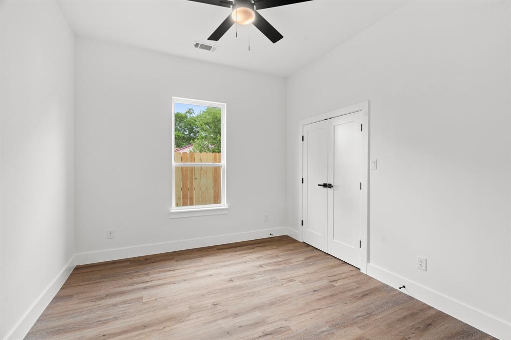 2227 Fordham Road Dallas, TX 75216 - Photo 21 of 30 an empty room with wooden floor ceiling fan and windows