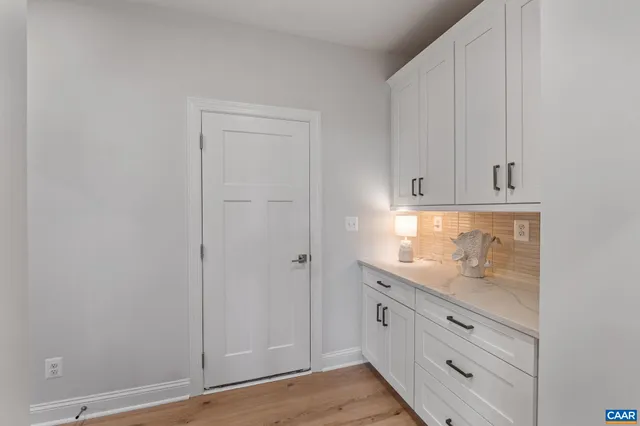 a kitchen with stainless steel appliances granite countertop a table chairs stove a sink dishwasher and cabinets