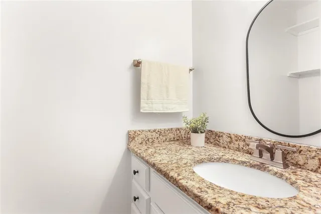 a bathroom with a granite countertop sink and a mirror
