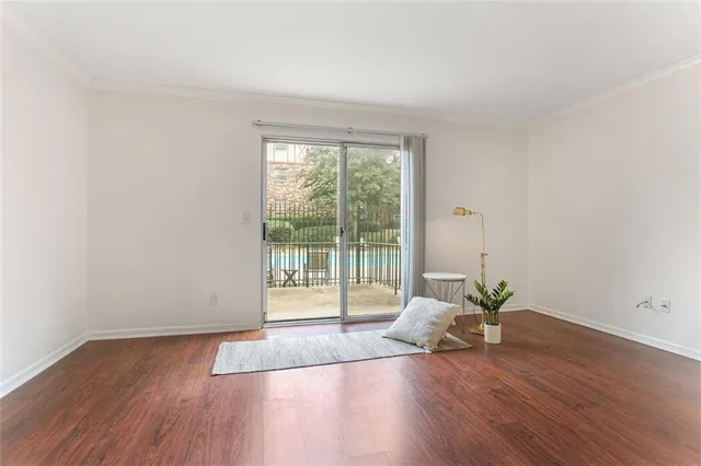 a living room with wooden floor and a floor to ceiling window