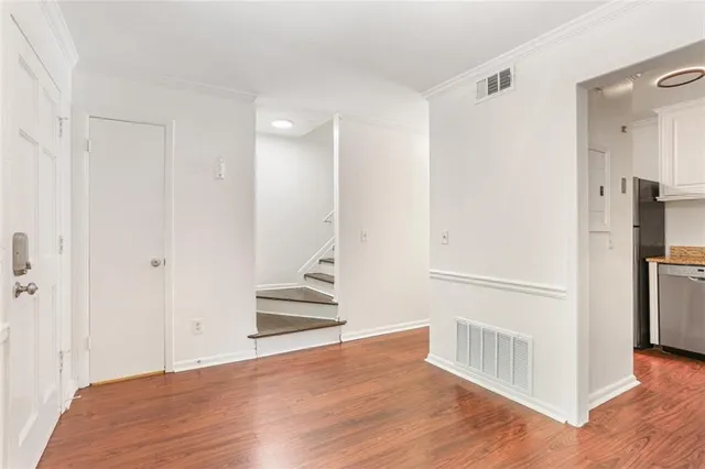 a view of a kitchen with wooden floor and a refrigerator