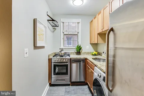 a kitchen with a stove top oven sink and window