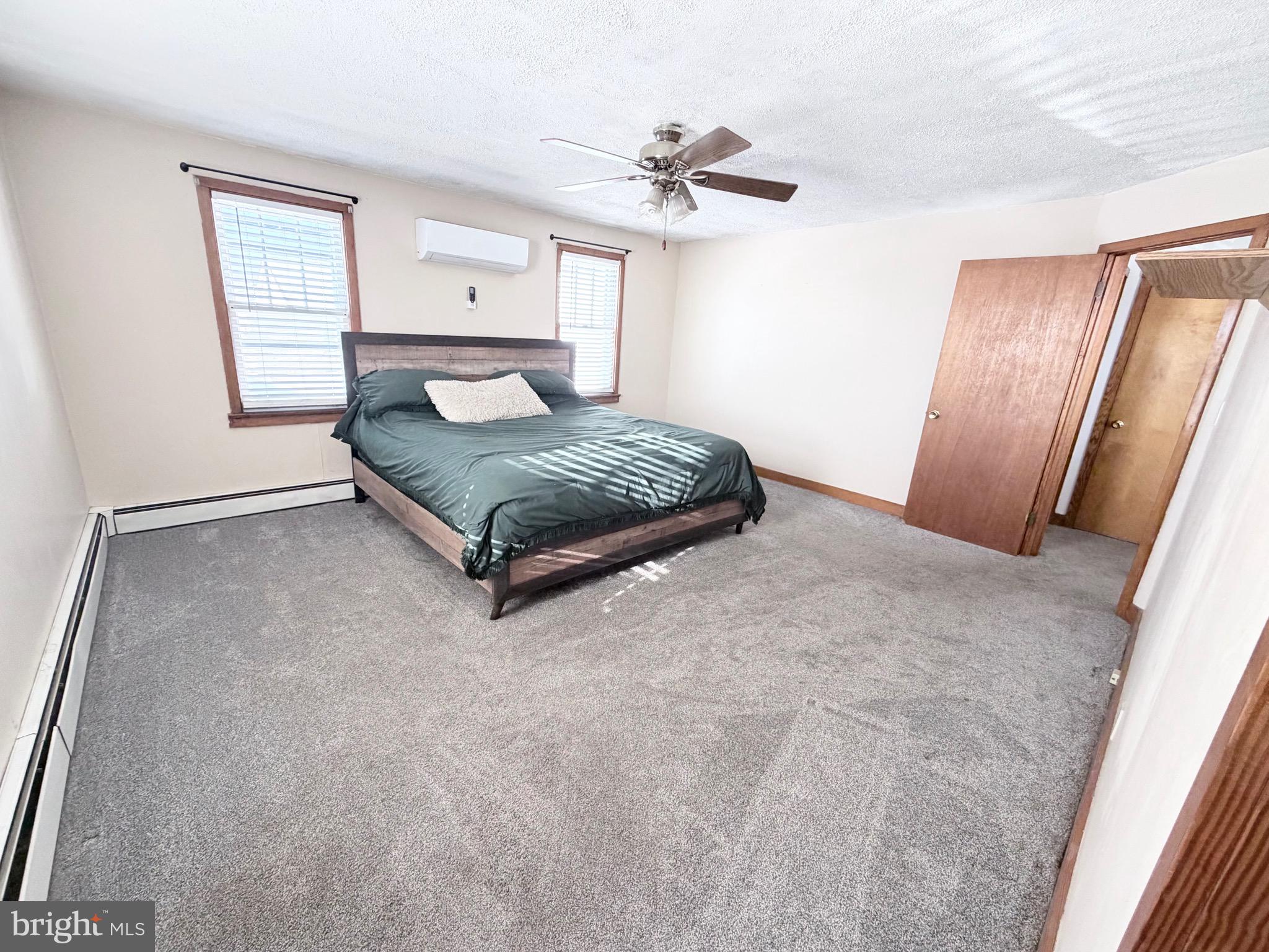181 West Mechanic Street Frostburg, MD 21532 - Photo 19 of 36 a spacious bedroom with a large bed and a chandelier