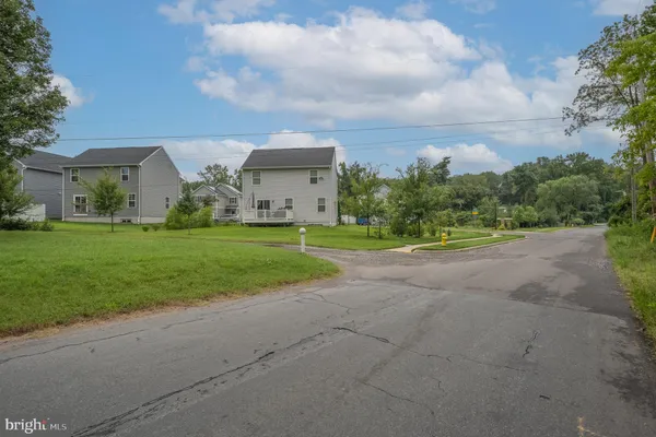 a view of a house with a big yard and large trees